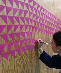 An image of a woman drawing a wall art
